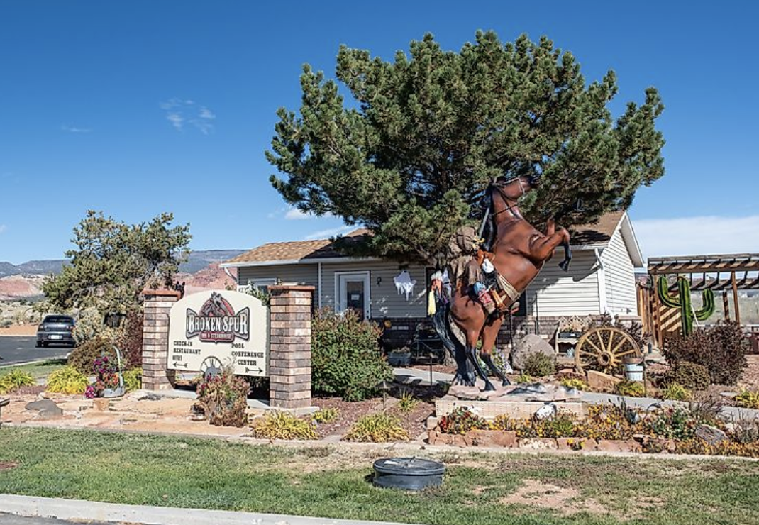 Broken Spur Inn and Steakhouse entrance sign with a rearing horse statue in Torrey, Utah