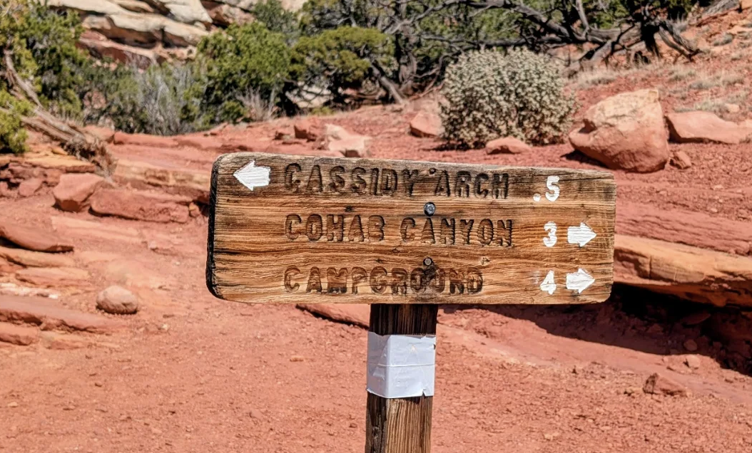 Wooden trail sign pointing to Cassidy Arch, Cohab Canyon and the campground in Capitol Reef National Park