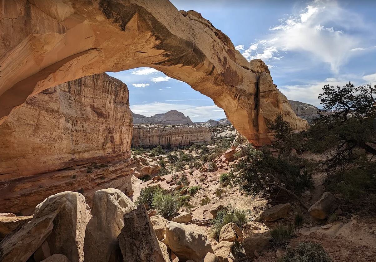View through a natural sandstone arch toward a distant butte in Capitol Reef National Park