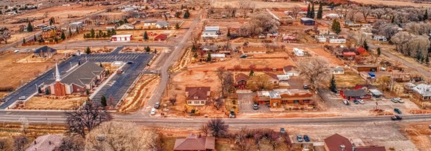 An aerial drone view of Torrey, Utah showing the church, Main Street and surrounding homes and trees